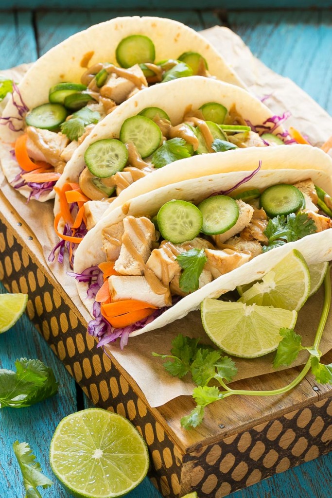 Estos tacos de pollo tailandeses son una cena rápida y fácil.  El pollo marinado con coco se rellena en tortillas calientes con verduras frescas y una generosa cantidad de salsa de maní casera.