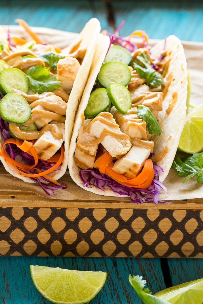 Estos tacos de pollo tailandeses son una cena rápida y fácil.  El pollo marinado con coco se rellena en tortillas calientes con verduras frescas y una generosa cantidad de salsa de maní casera.