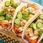 Estos tacos de pollo tailandeses son una cena rápida y fácil.  El pollo marinado con coco se rellena en tortillas calientes con verduras frescas y una generosa cantidad de salsa de maní casera.