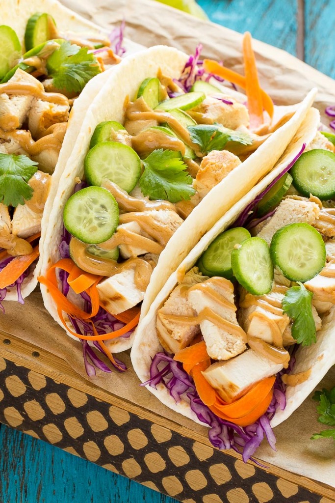 Estos tacos de pollo tailandeses son una cena rápida y fácil.  El pollo marinado con coco se rellena en tortillas calientes con verduras frescas y una generosa cantidad de salsa de maní casera.