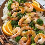 Estos camarones con brócoli y naranja con arroz frito con ajo y sésamo son la comida rápida y fácil perfecta para una noche divertida o entre semana.  ANUNCIO
