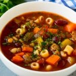 Un plato de pasta y sopa de frijoles con verduras de colores, pasta ditalini, dos tipos de frijoles y carne molida.