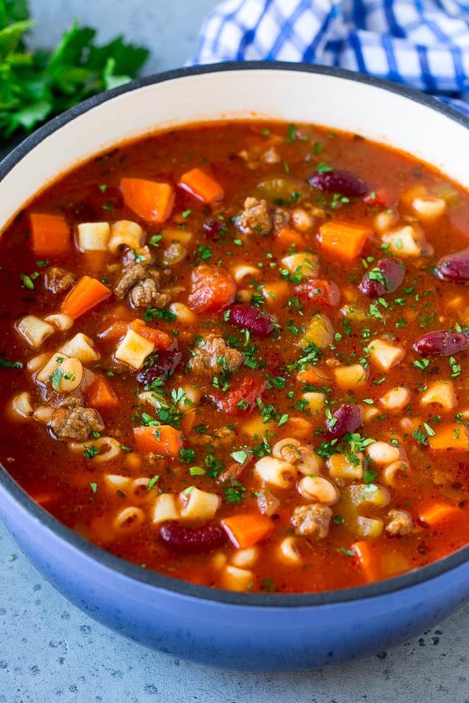Una olla de sopa de fideos y frijoles hecha de carne picada, verduras, frijoles y pasta.
