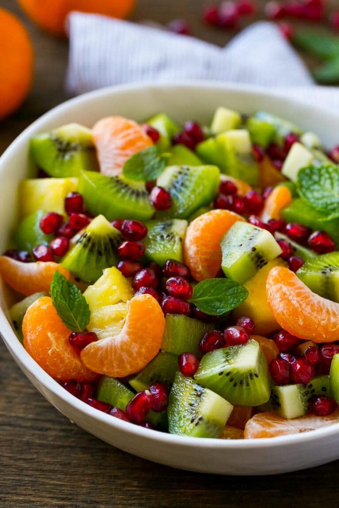 Esta ensalada de frutas de invierno está hecha con naranjas, kiwis, piñas y granadas.