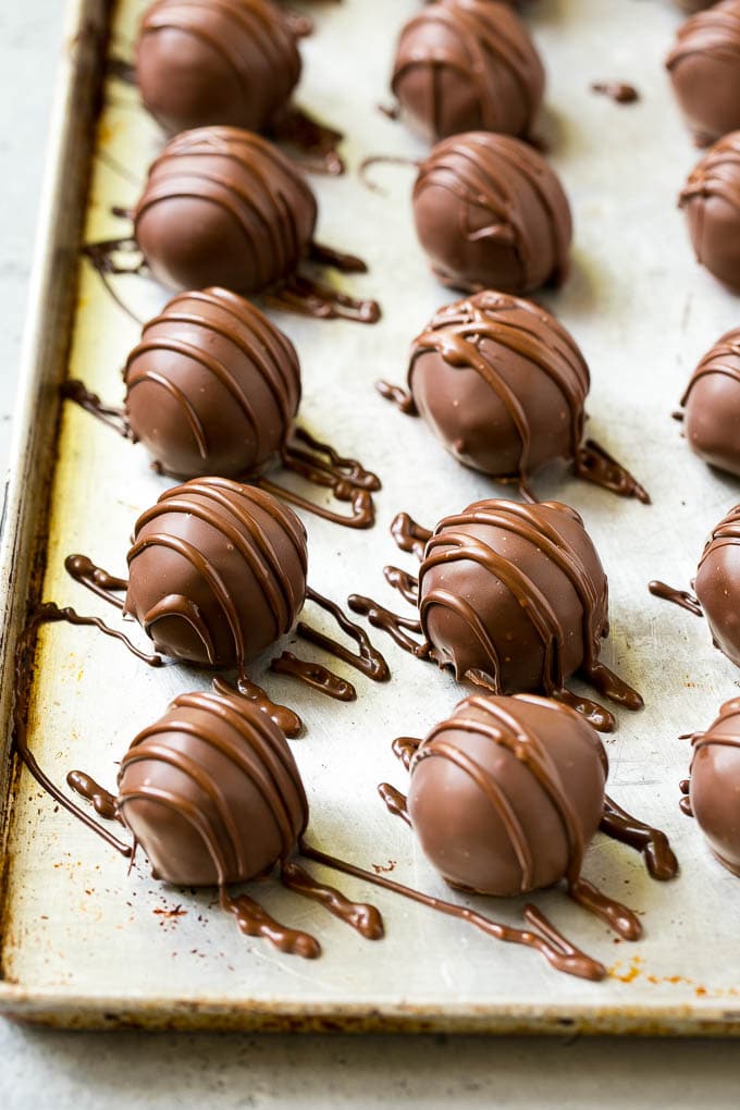 Cerezas cubiertas de chocolate con un chorrito de chocolate encima.