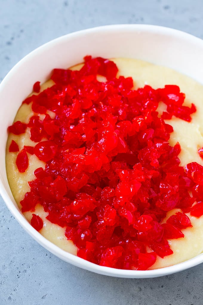 Masa para muffins cubierta con cerezas al marrasquino picadas.