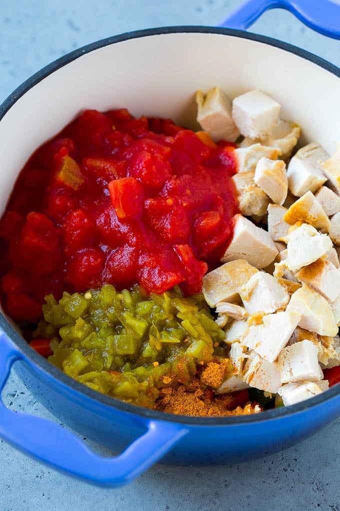 Verduras, pollo, pimientos y tomates en una cacerola.