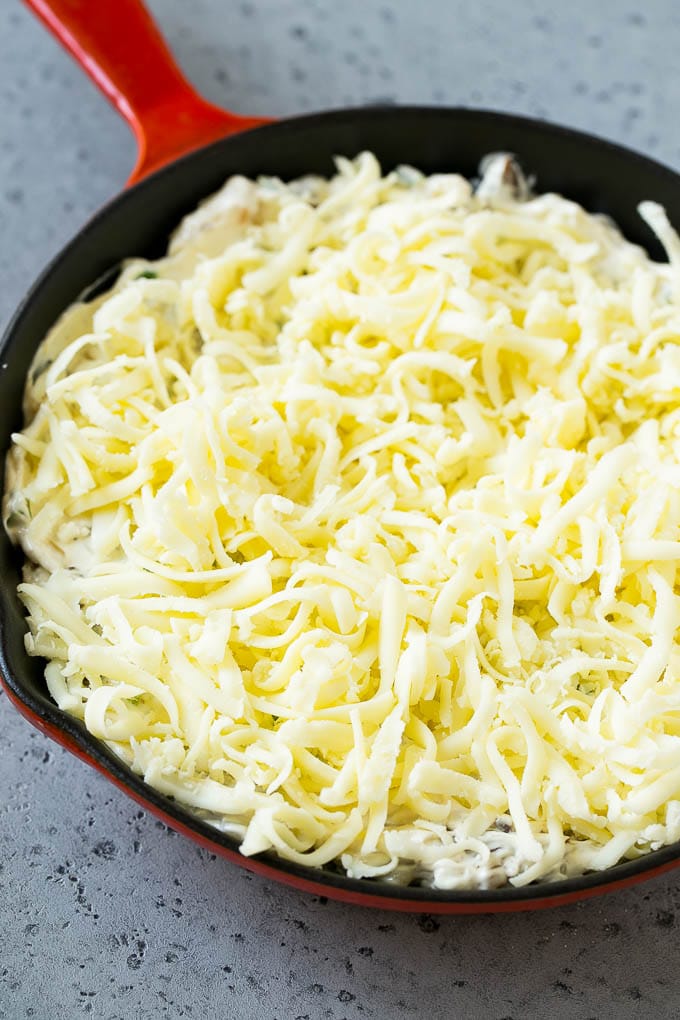Philly Cheesesteak Dip con queso rallado encima, esperando para entrar al horno.