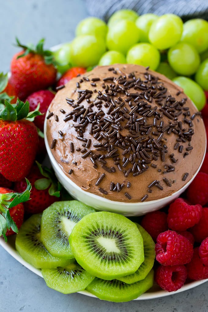 Un tazón de salsa de frutas de chocolate adornado con chispitas.