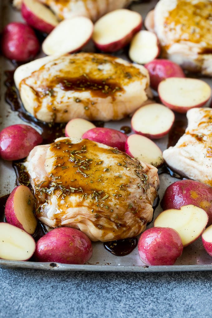 Receta de pollo balsámico | Pollo en un plato | Pollo glaseado # pollo # espárragos # papas # cena # sin gluten #dinneratthezoo Muslos de pollo y papas en una bandeja para hornear cubierta con salsa balsámica.