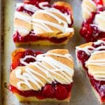 Barritas de cereza hechas con masa de galletas de almendras en una bandeja para hornear.