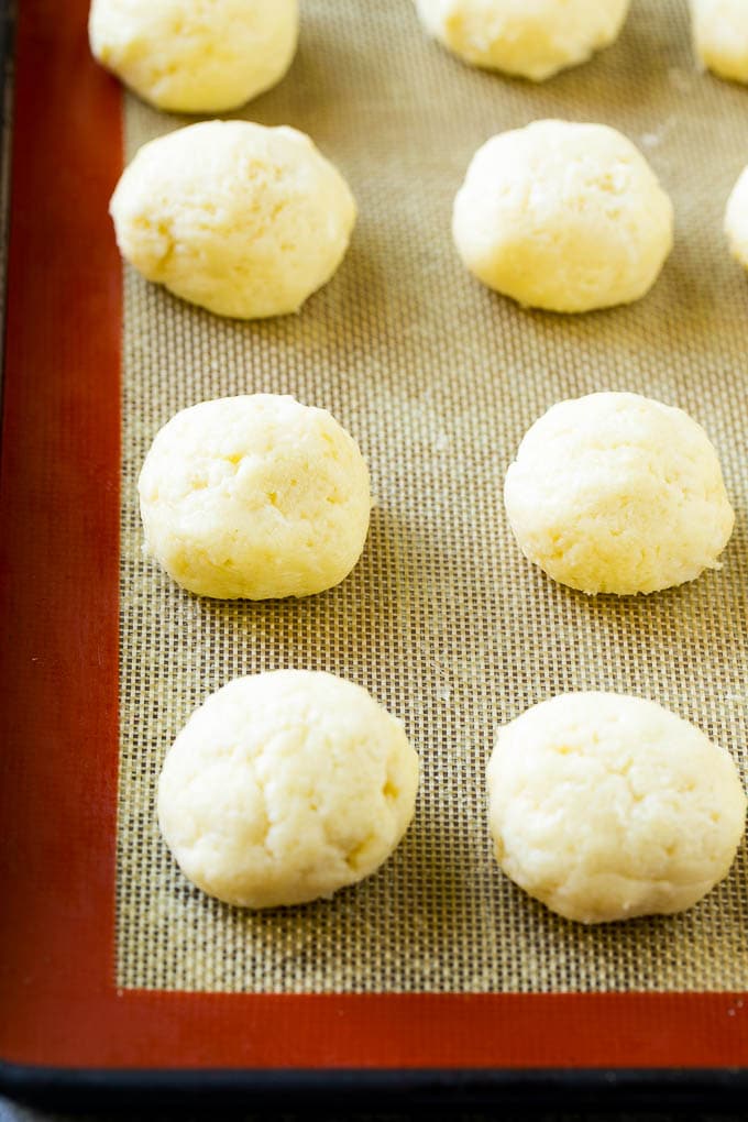 Bolas de masa de galleta de mantequilla pegajosa en una bandeja para hornear.