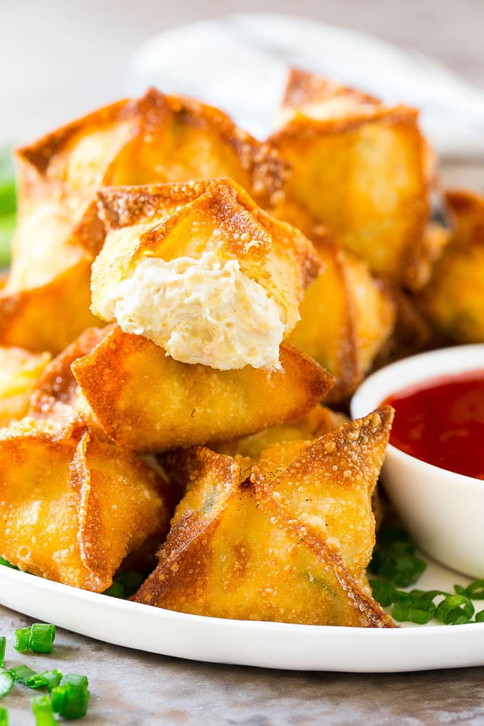 Receta de cangrejo de Rangún | Wonton de cangrejo | Wonton de queso crema # cangrejo # queso #aperitivo # merienda #comida china # cena #dinneratthezoo Un corte transversal de rangoon de cangrejo con wonton crujiente relleno de queso crema y cangrejo.