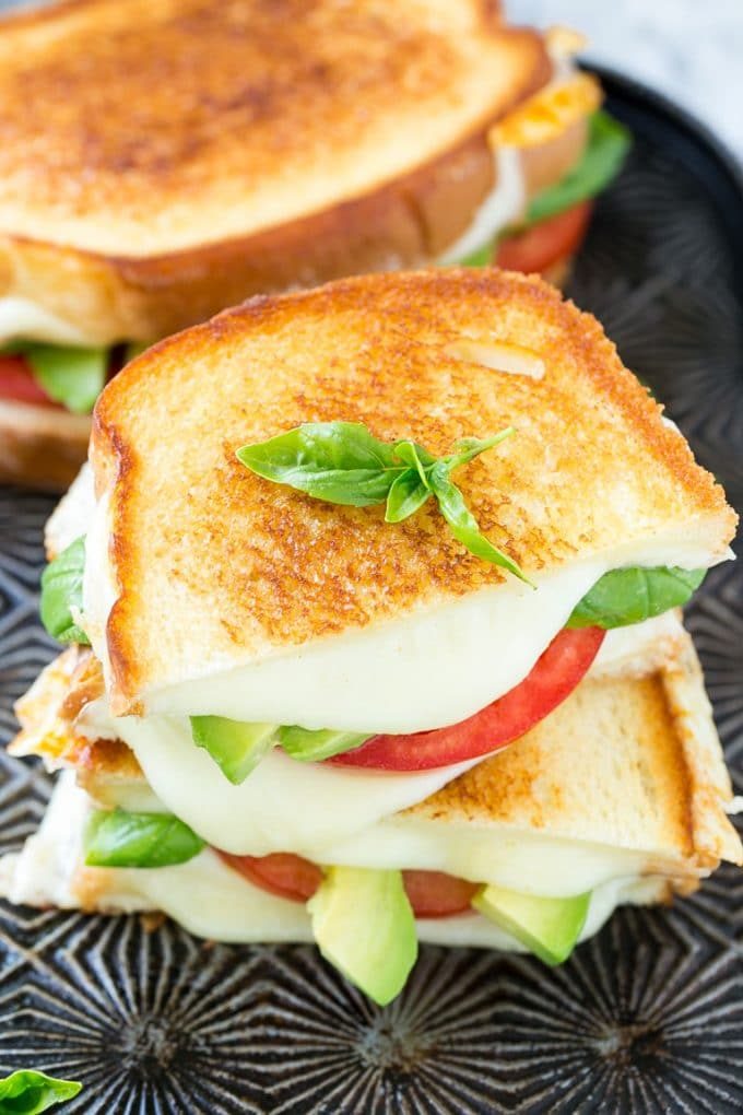 Sándwich Caprese | Receta de sándwich de queso a la parrilla #sandwich #caprese #fromage #queso a la parrilla # almuerzo # cena #Cazuelas online# aguacate Un sándwich caprese a la plancha con rodajas de tomate, queso fundido y aguacate.