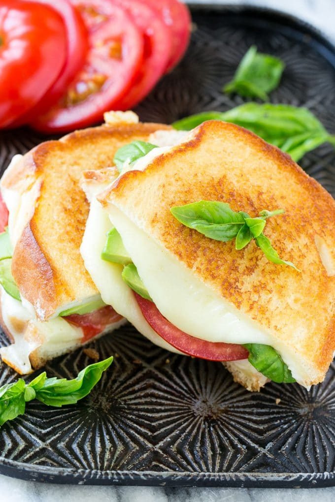 Sándwich Caprese | Receta de sándwich de queso a la parrilla #sandwich #caprese #Queso #Queso a la parrilla #Almuerzo # Cena #Cazuelas online#aguacate Sándwich caprese con mozzarella derretida, tomates frescos, rodajas de aguacate y hojas de albahaca.