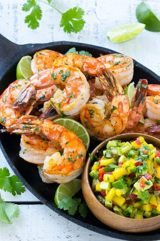 Una cacerola de cilantro braseado y langostinos a la lima con salsa de frutas.