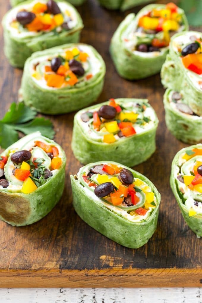 Rollos de carrete mexicano con queso, frijoles, pimientos coloridos y aderezos.
