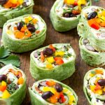 Esta receta de molino de viento mexicano consta de dos tipos de queso, frijoles negros y vegetales coloridos, todo envuelto en tortillas y cortado en aros.  ¡El aperitivo o aperitivo preenvasado perfecto!