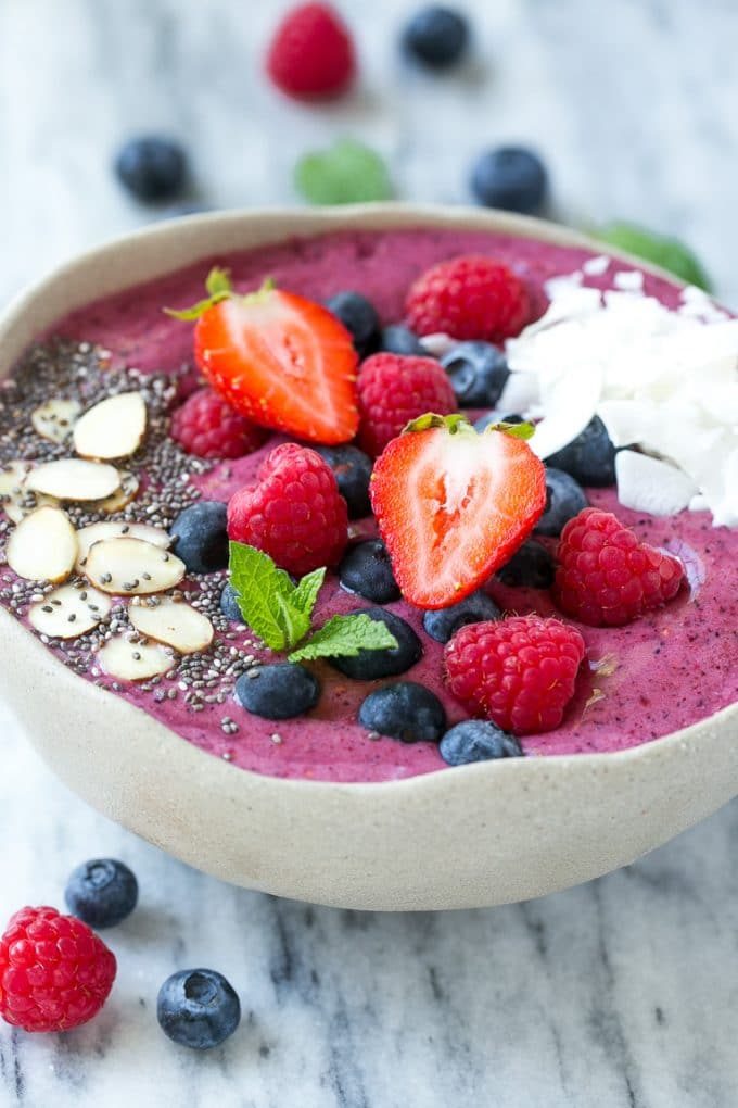 Un tazón de acai con coberturas frescas de fresas y arándanos.