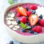Esta receta de tazón de acai es un batido a base de frutas, puré de bayas de acai y yogur que se sirve en un tazón y se complementa con una variedad divertida y colorida de aderezos.