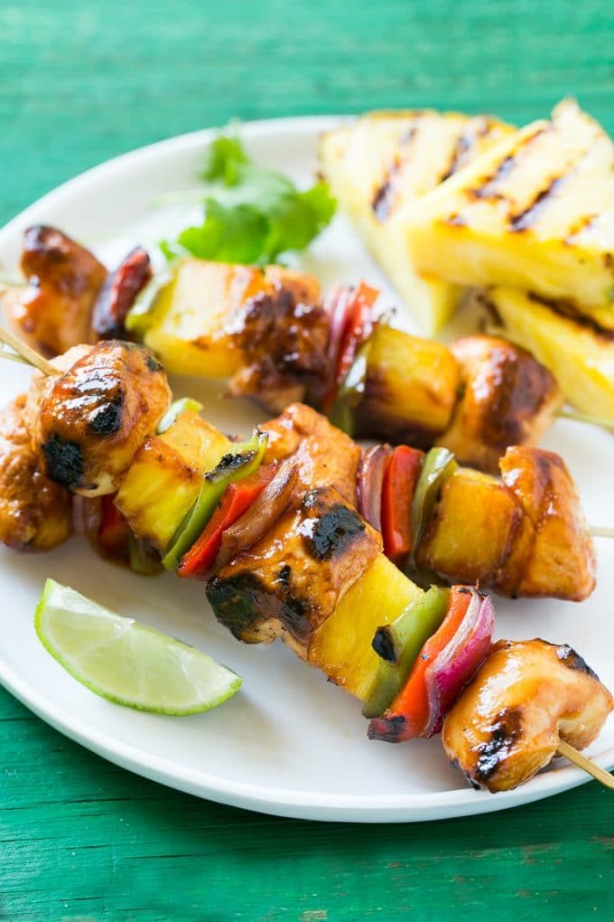 Brochetas de pollo dulces y saladas con piña y verduras.