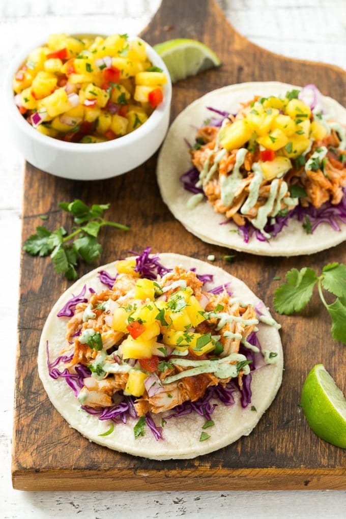 Mini tortillas de maíz cubiertas con repollo morado y pollo desmenuzado.