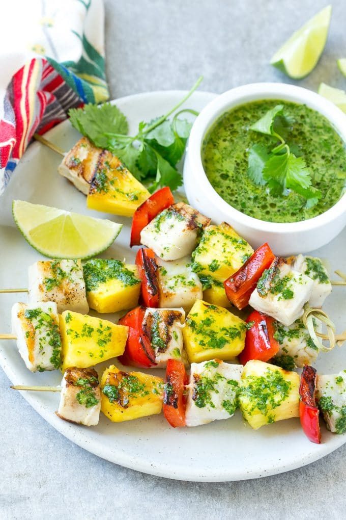 Brochetas de mojo de pescado con piña y pimientos en un plato para servir.