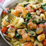 Esta receta de pasta de pollo toscana está hecha con pasta cremosa cubierta con pollo chamuscado, tomates, col rizada y champiñones.  ¡Una cena sencilla y abundante lista en poco tiempo!