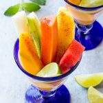 Esta receta de Copa de Fruta Mexicana está hecha con lanzas de frutas tropicales, apiladas en un vaso y espolvoreadas con aderezo de chile.  ¡Una versión refrescante y única de la ensalada de frutas!