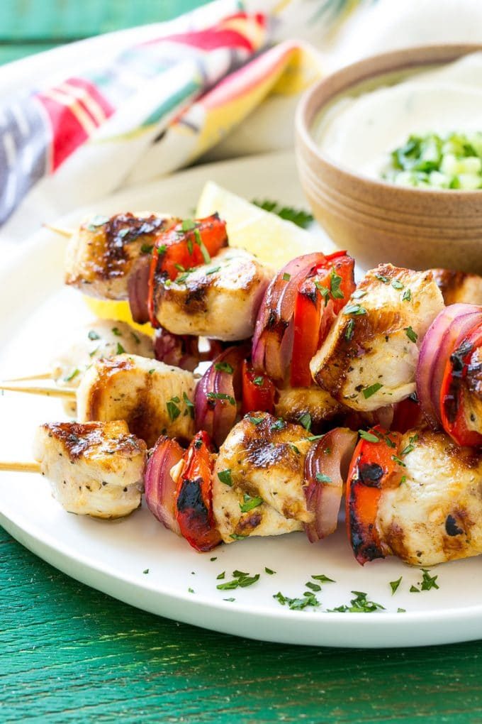 Una pila de brochetas de pollo griego hechas con pimientos y cebollas.