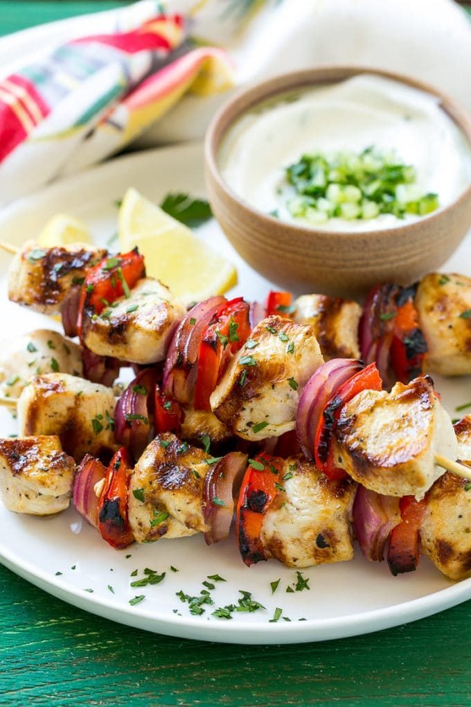 Brochetas de pollo al estilo griego adornadas con perejil fresco.