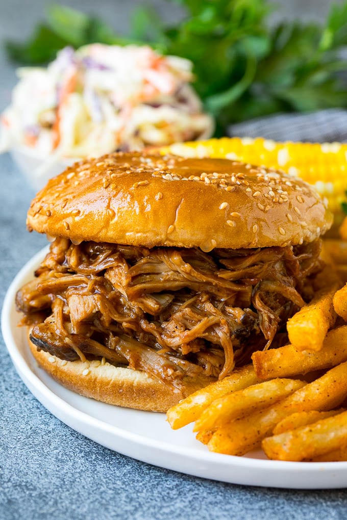Receta de cerdo ahumado | Paletilla de cerdo ahumada #fumador # cerdo #pulledpork #diner #dinneratthezoo Un sándwich de puerco desmenuzado ahumado servido con patatas fritas.