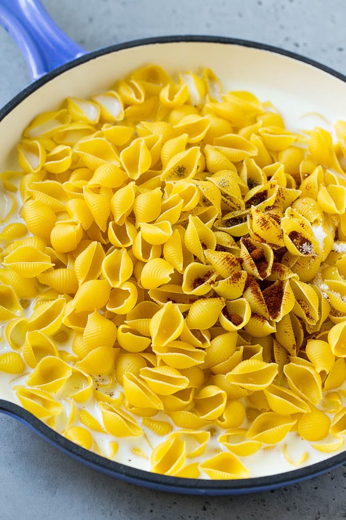 Pele la pasta y las especias en la leche en una sartén antiadherente.