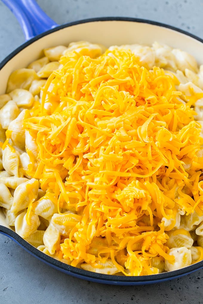 Pasta cremosa cubierta con un manojo de queso cheddar rallado.