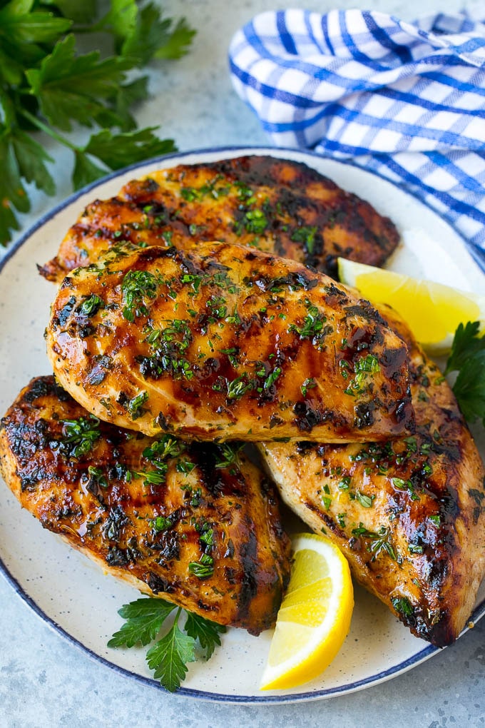 Un plato de pechuga de pollo a la plancha servido con perejil y limón.