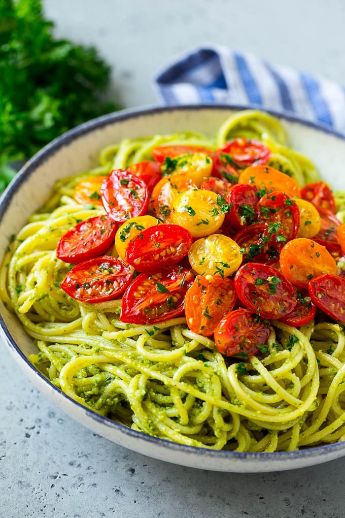 Pasta con pesto cubierta con tomates cherry asados.