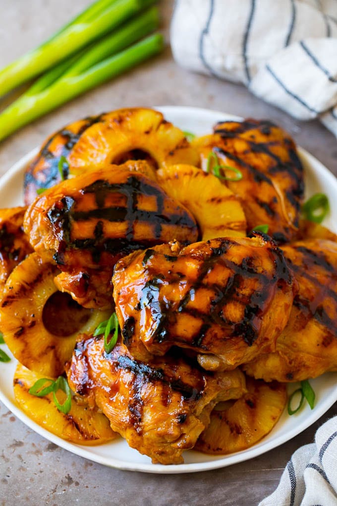 Un plato lleno de pollo huli huli y piña asada.