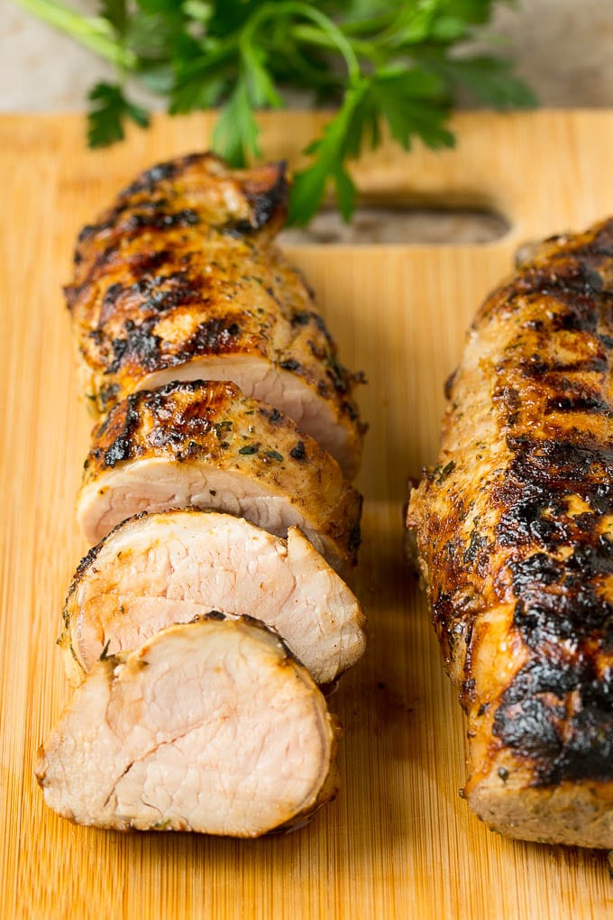 Lomo de cerdo en rodajas sobre una tabla para cortar.