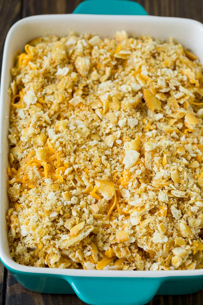 Calabaza en una fuente para hornear cubierta con migas de galleta y queso cheddar.