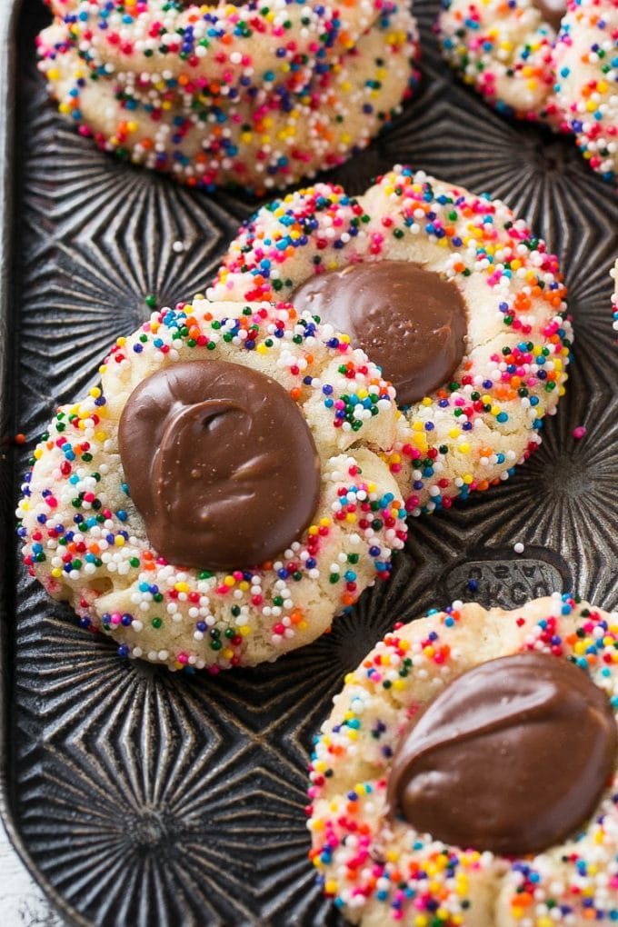 Galletas cubiertas con chispas de arco iris y un centro de fondant.