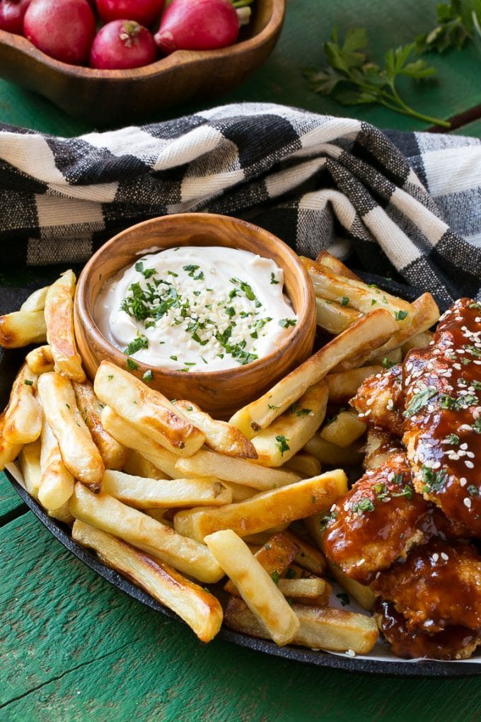 Una sartén de papas fritas y palitos de pollo.