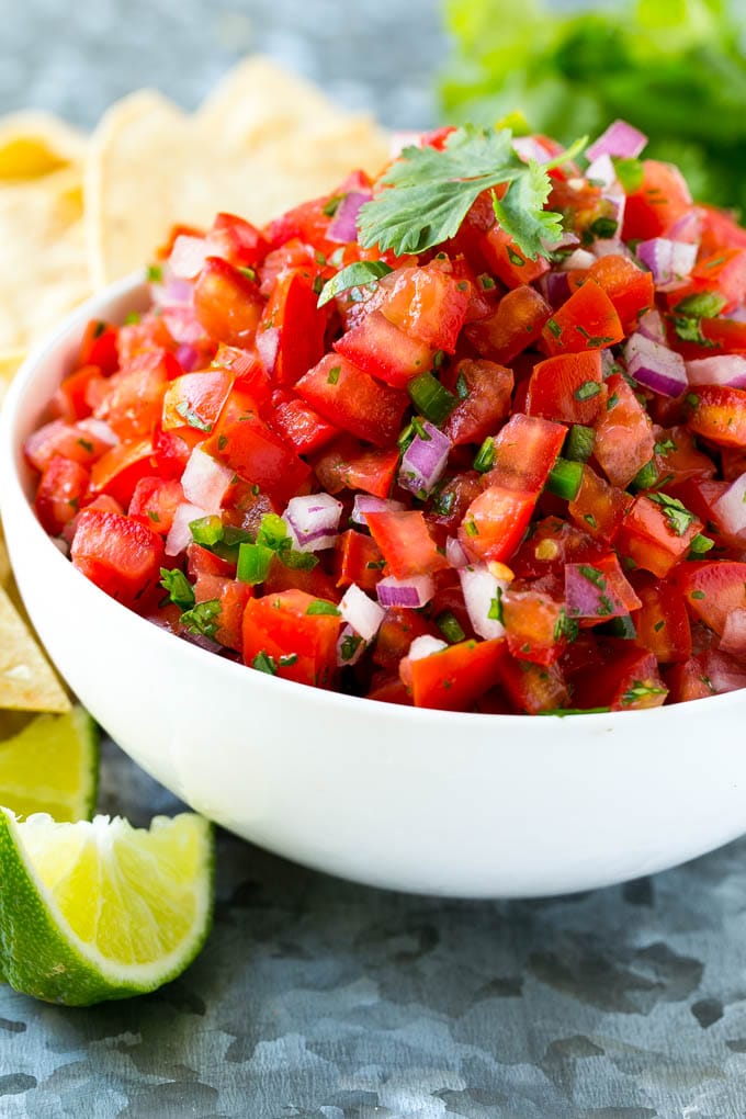 Un tazón de pico de gallo casero rodeado de totopos.