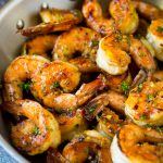 Adobo de camarones sobre camarones cocidos, aderezado con perejil.
