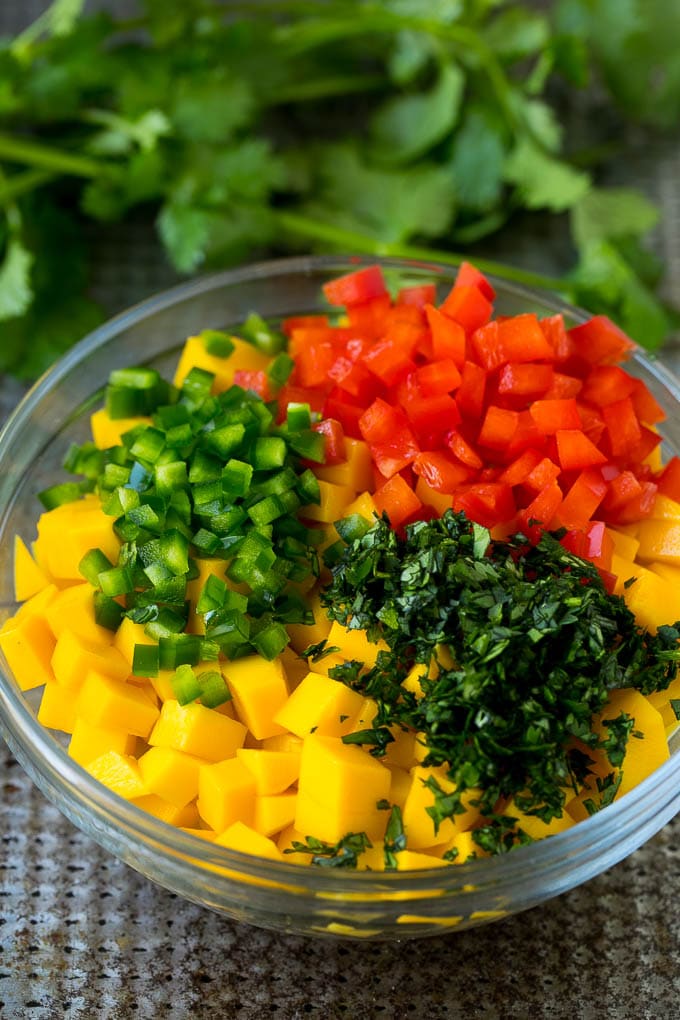 Receta de taco de camarones | Tacos de pescado #shrimp #tacos #mango #tacotuesday #mexican #dinner #dinneratthezoo Mango cortado en cubitos, jalapeño, chile y cilantro en un bol.