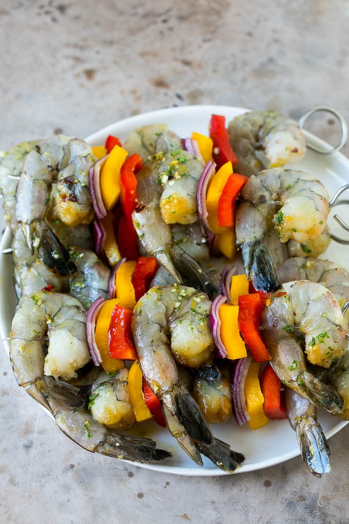 Camarones crudos en brochetas con pimientos y cebollas.