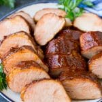 Lomo de cerdo ahumado en rodajas en un plato para servir.