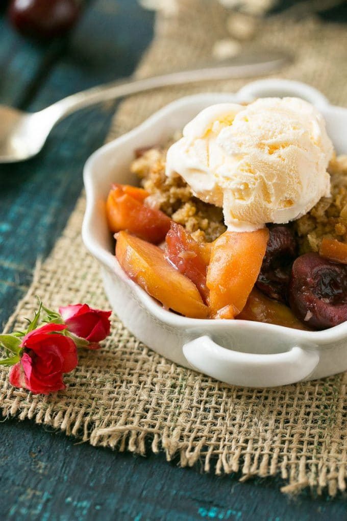 Un tazón de fruta crujiente cubierto con helado de vainilla.