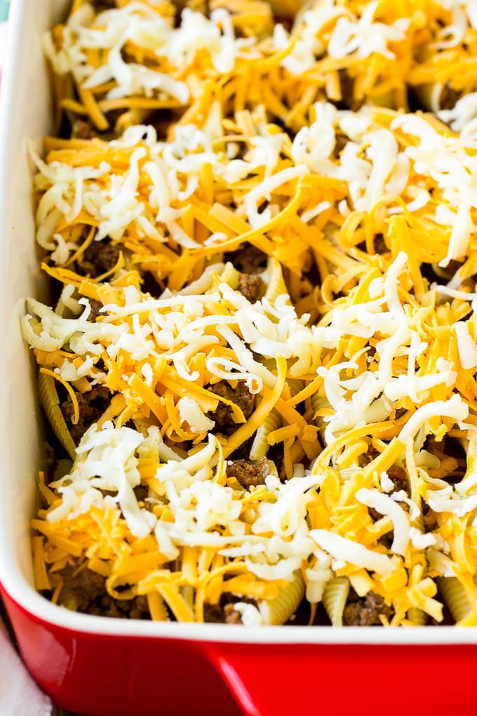 Conchas rellenas mexicanas crudas cubiertas con queso rallado.