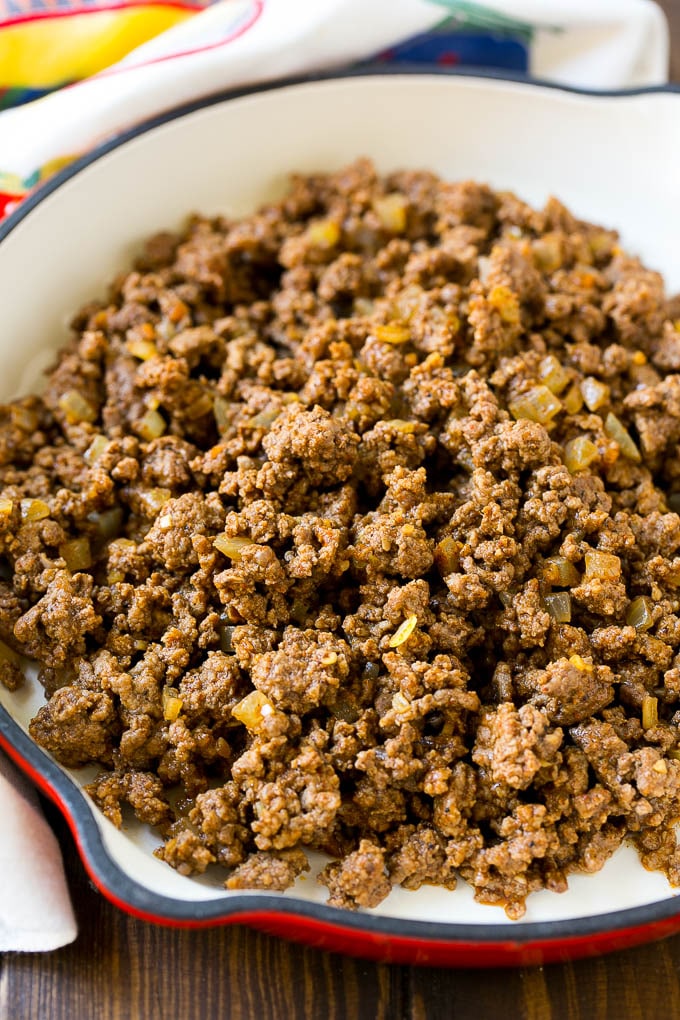 Una cazuela de carne picada cubierta con taco y cebolla.