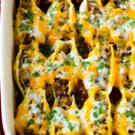 Una sartén de conchas rellenas mexicanas rellenas de carne molida y queso.